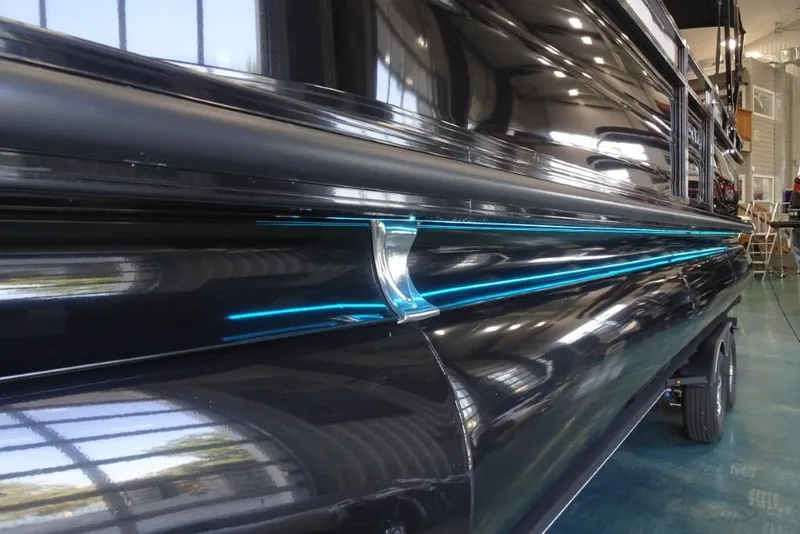 Slide: The Image of 2024 Regency 250 LE3 boat with sleek black exterior and blue accent lighting. - 10