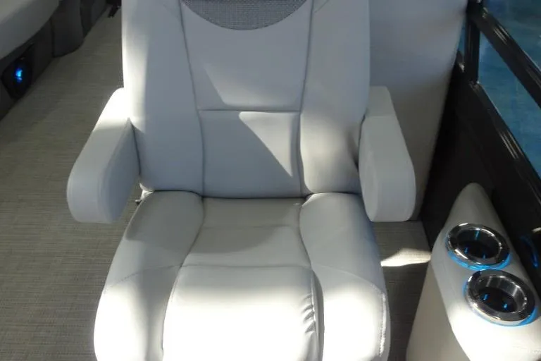 Slide: The Image of 2024 Regency 250 LE3 luxury boat seat with armrests and cup holders. - 16