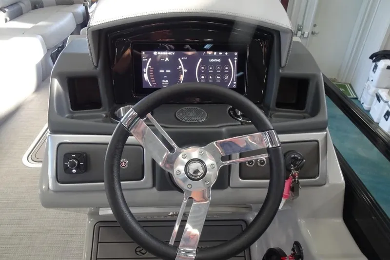 Slide: The Image of 2024 Regency 250 LE3 boat dashboard with steering wheel and digital display. - 19