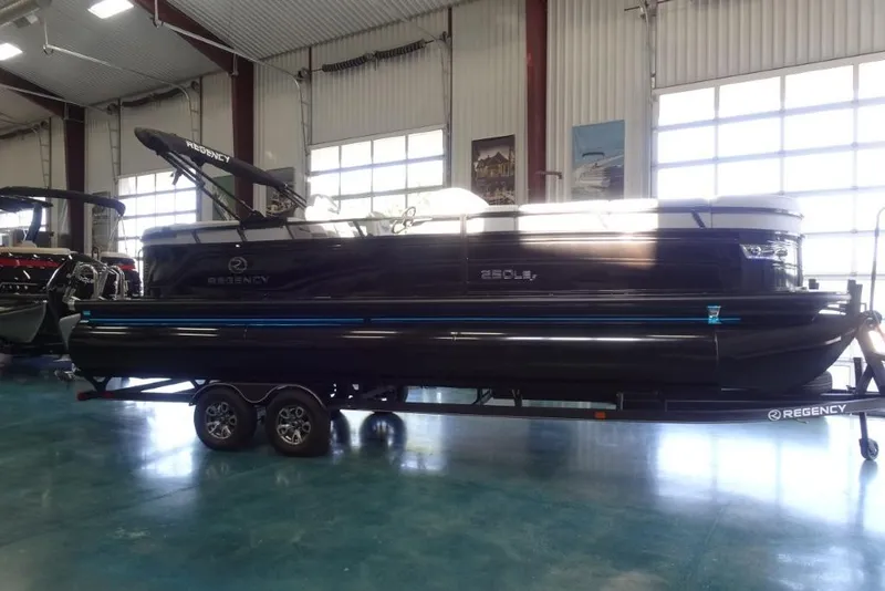 Slide: The Image of 2024 Regency 250 LE3 pontoon boat on trailer in showroom. - 2