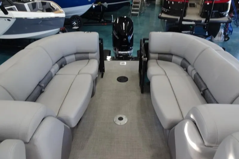 Slide: The Image of 2024 Regency 250 LE3 pontoon boat interior with plush seating and outboard motor. - 21