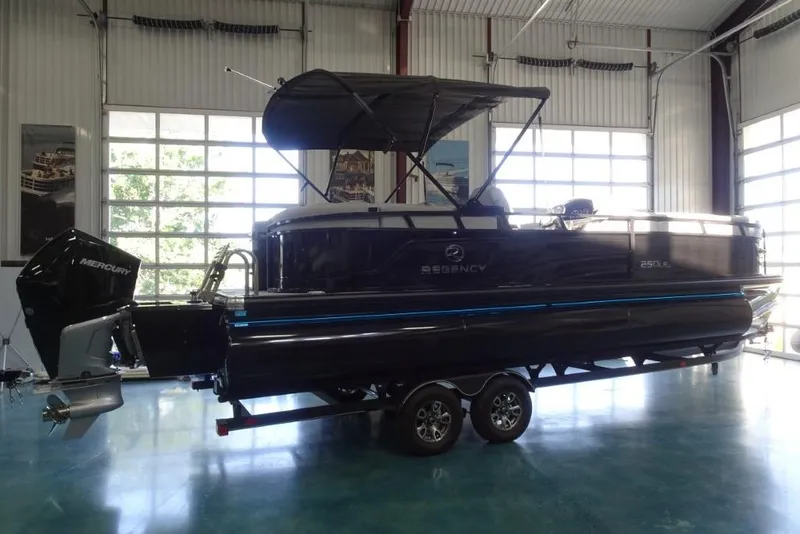 Slide: The Image of 2024 Regency 250 LE3 pontoon boat in a showroom with Mercury outboard motor. - 3