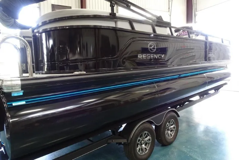Slide: The Image of 2024 Regency 250 LE3 pontoon boat on trailer in indoor setting. - 5