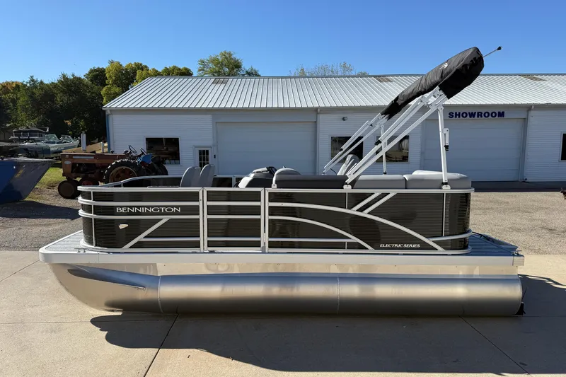 Slide: The Image of 2026 Bennington 168 SF Electric pontoon boat outside showroom, featuring sleek design and modern amenities. - 4