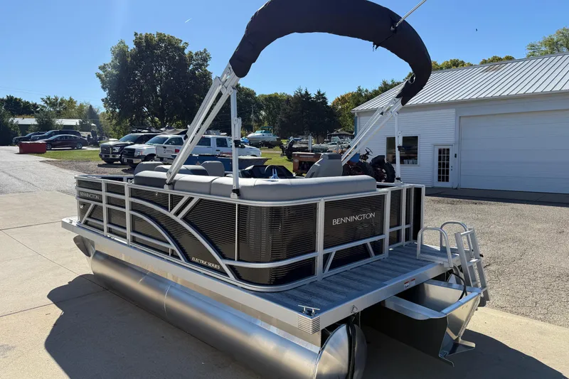 Slide: The Image of 2026 Bennington 168 SF Electric pontoon boat with canopy, parked outdoors. - 5