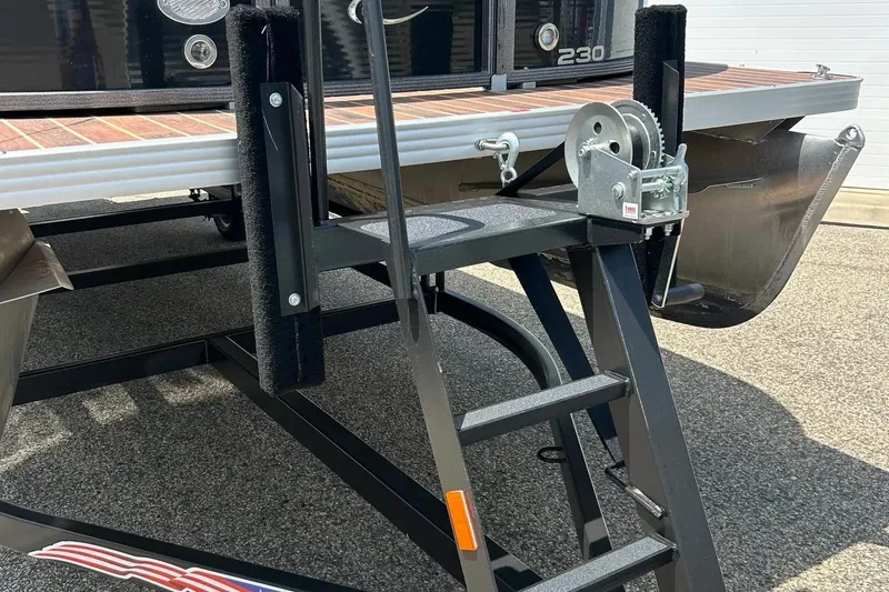 Slide: The Image of 2014 Crest 230 Crest II SLC boat trailer with winch and ladder on asphalt. - 11