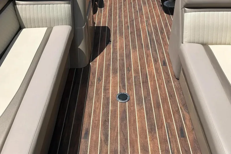Slide: The Image of 2014 Crest 230 Crest II SLC boat interior with wood-patterned flooring and beige seating. - 12