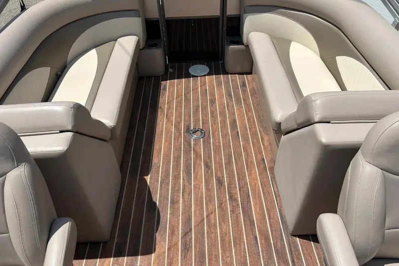Slide: The Image of Interior of 2014 Crest 230 Crest II SLC pontoon boat with beige seating and wood flooring. - 2