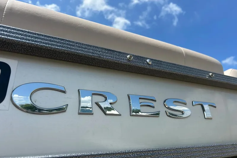 Slide: The Image of 2014 Crest 230 Crest II SLC boat with chrome logo under blue sky. - 33