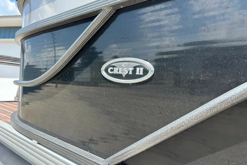 Slide: The Image of 2014 Crest 230 Crest II SLC boat emblem on a sleek black surface. - 6