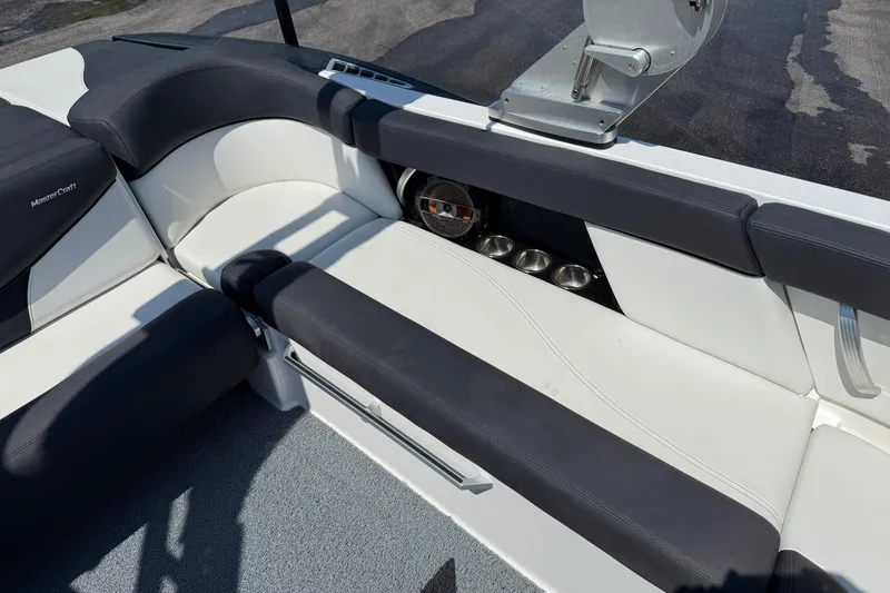 Slide: The Image of 2019 MasterCraft XT22 boat interior with black and white seating and cup holders. - 22