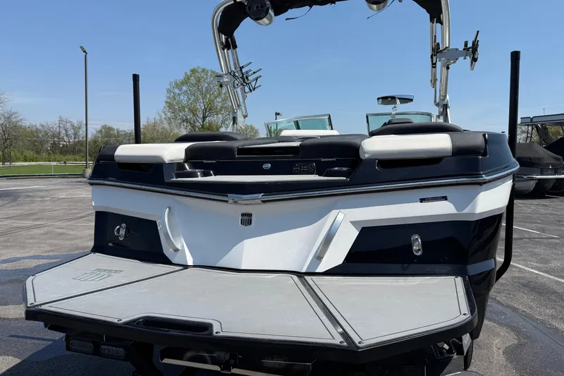 Slide: The Image of 2019 MasterCraft XT22 boat, rear view, parked outdoors on a sunny day. - 3