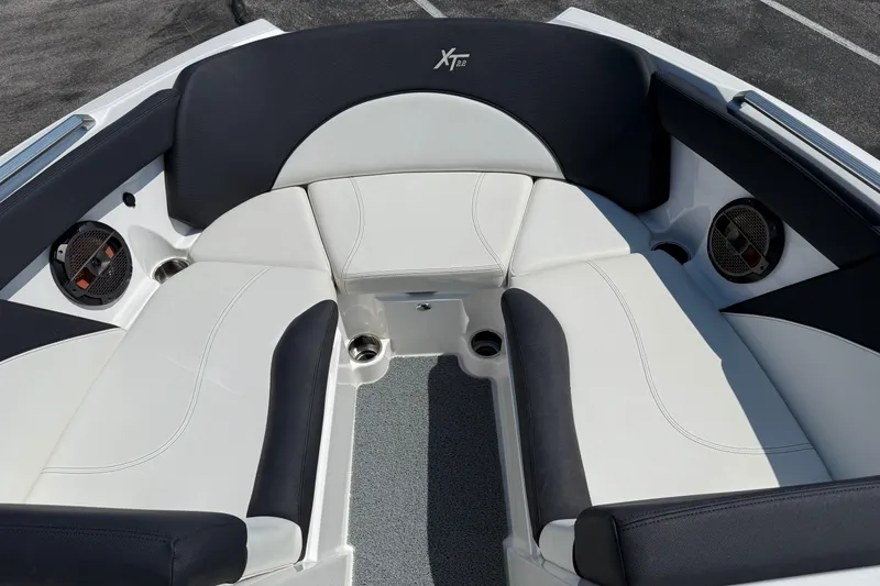 Slide: The Image of 2019 MasterCraft XT22 boat interior with white and black seating, featuring built-in speakers. - 7