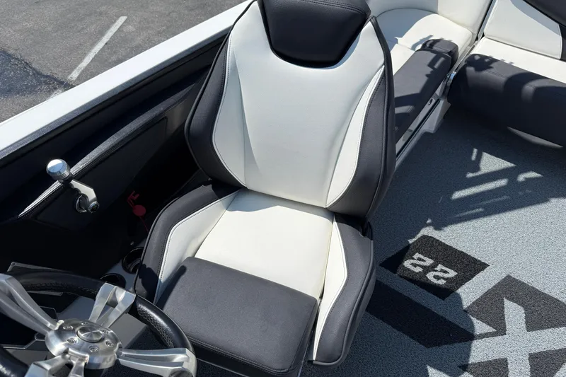 Slide: The Image of 2019 MasterCraft XT22 boat interior with sleek black and white seating and steering wheel. - 8