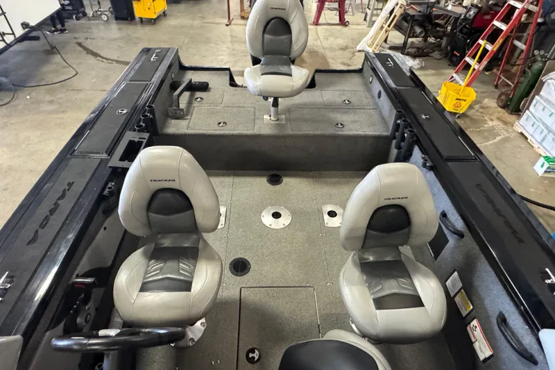 Slide: The Image of 2019 Tracker Targa V-18 WT boat interior with four gray seats in a workshop setting. - 14