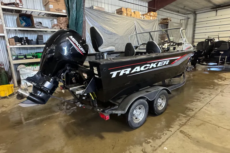 Slide: The Image of 2019 Tracker Targa V-18 WT boat in a garage, featuring a Mercury outboard motor. - 4