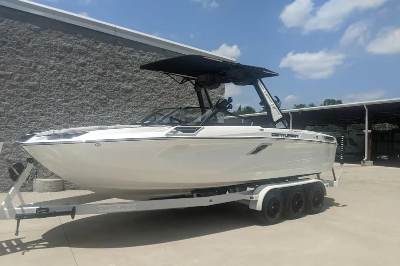 Slide: The Image of 2022 Centurion Ri245 boat on trailer, parked outdoors under a clear sky. - 1