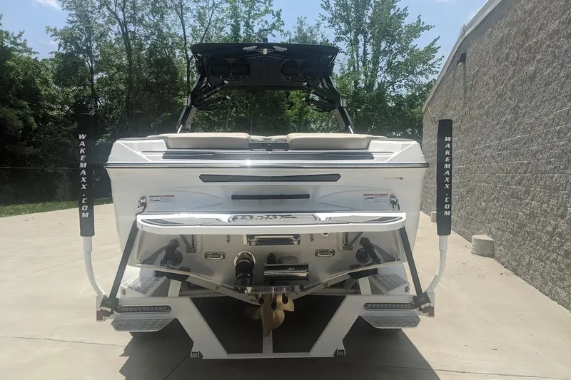 Slide: The Image of 2022 Centurion Ri245 boat rear view, parked outdoors, showcasing sleek design and features. - 2