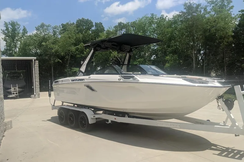 Slide: The Image of 2022 Centurion Ri245 boat on trailer, parked outdoors with trees in background. - 3