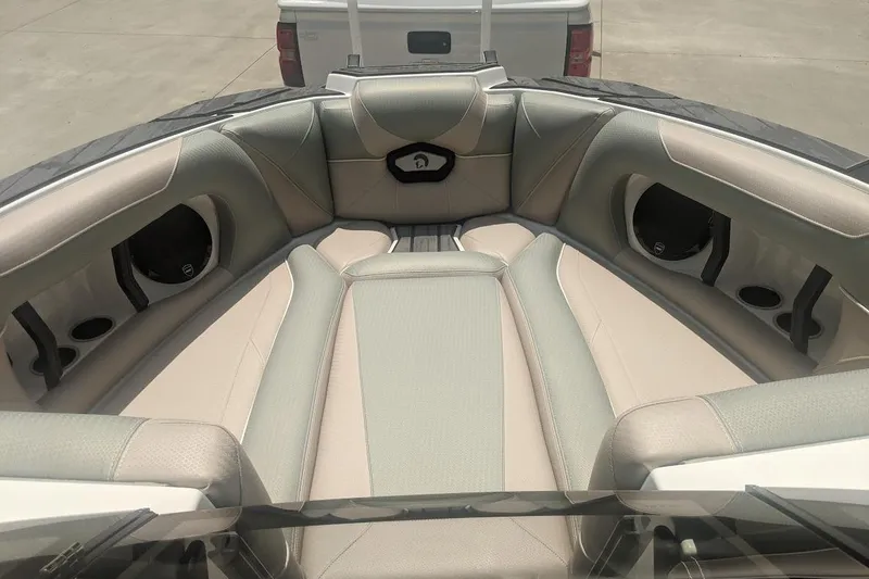 Slide: The Image of 2022 Centurion Ri245 boat interior with beige seating and cup holders. - 6