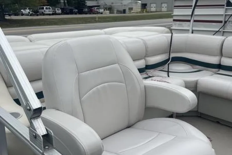 Slide: The Image of 1999 Bennington Twin-Toon boat interior with white cushioned seating and armrests. - 11