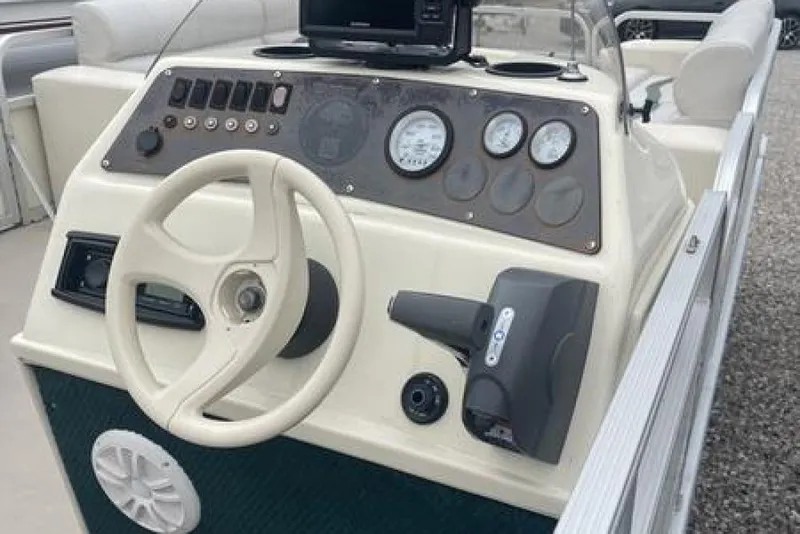 Slide: The Image of 1999 Bennington Twin-Toon boat dashboard with steering wheel and gauges. - 14