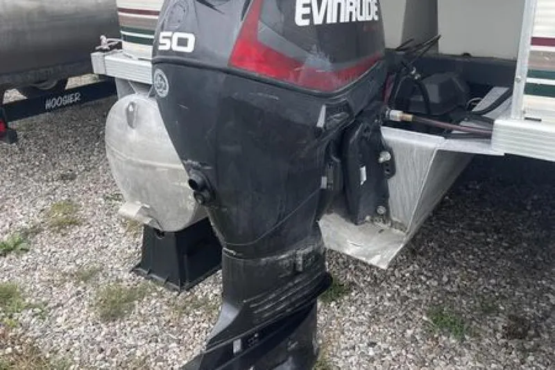 Slide: The Image of 1999 Bennington twin-toon with Evinrude 50 outboard motor on gravel surface. - 15