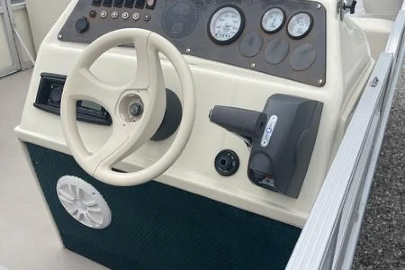 Slide: The Image of 1999 Bennington Twin-Toon boat dashboard with steering wheel and control panel. - 16