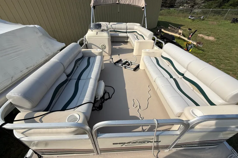 Slide: The Image of 1999 Bennington twin-toon pontoon boat with spacious seating and canopy, parked outdoors. - 17