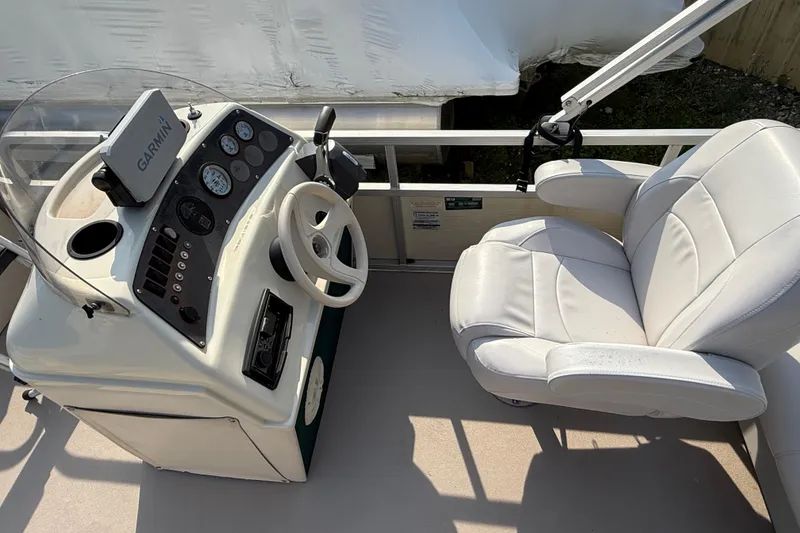 Slide: The Image of 1999 Bennington Twin-Toon boat helm with Garmin GPS, steering wheel, and white captain's chair. - 20