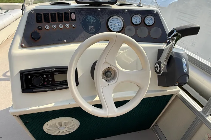 Slide: The Image of 1999 Bennington Twin-Toon boat dashboard with steering wheel and control panel. - 21