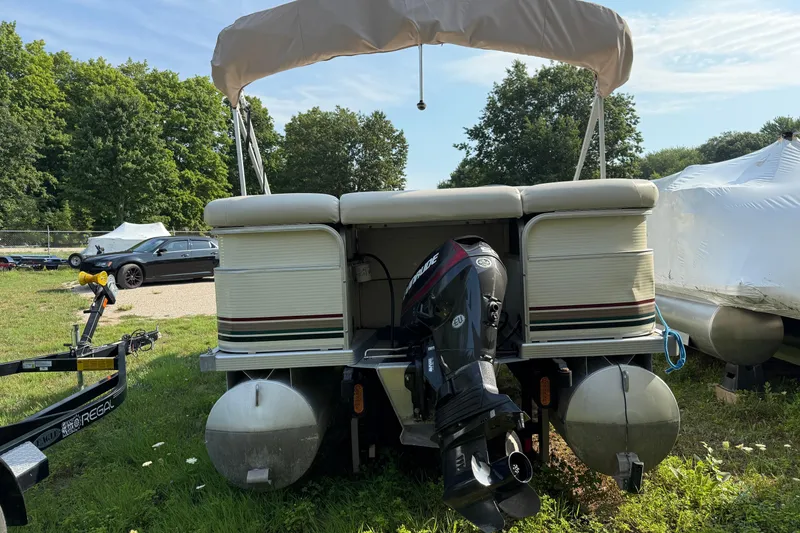 Slide: The Image of 1999 Bennington Twin-Toon pontoon boat with outboard motor, parked on grass. - 3