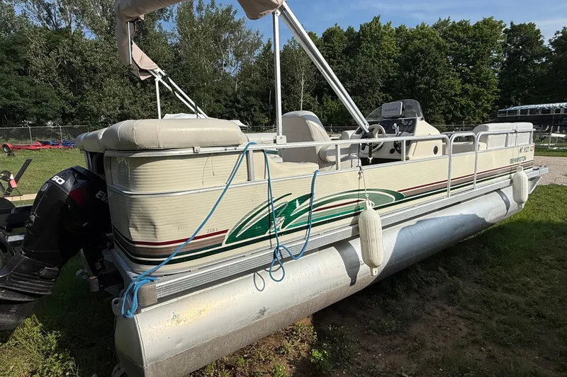 Slide: The Image of 1999 Bennington twin-toon pontoon boat on grass, with outboard motor and canopy. - 4