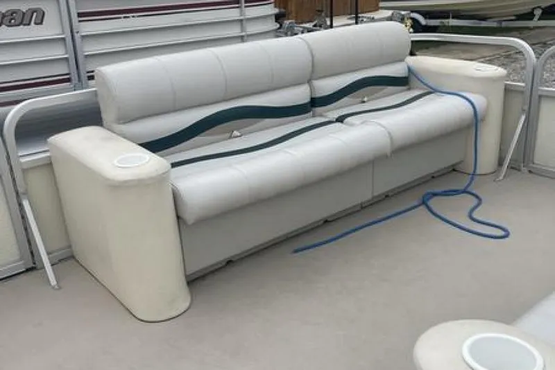 Slide: The Image of White seating on a 1999 Bennington Twin-Toon boat with blue rope and cup holders. - 7