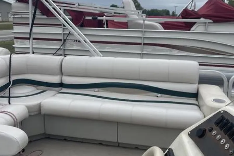 Slide: The Image of 1999 Bennington Twin-Toon pontoon boat with white seating and control panel. - 9