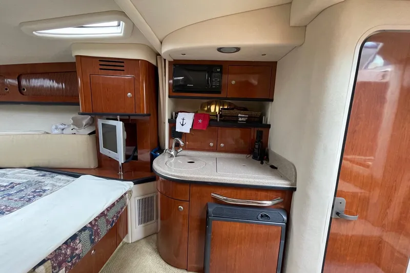 Slide: The Image of 2007 Sea Ray 290 Sundancer cabin interior with kitchenette and cozy sleeping area. - 11