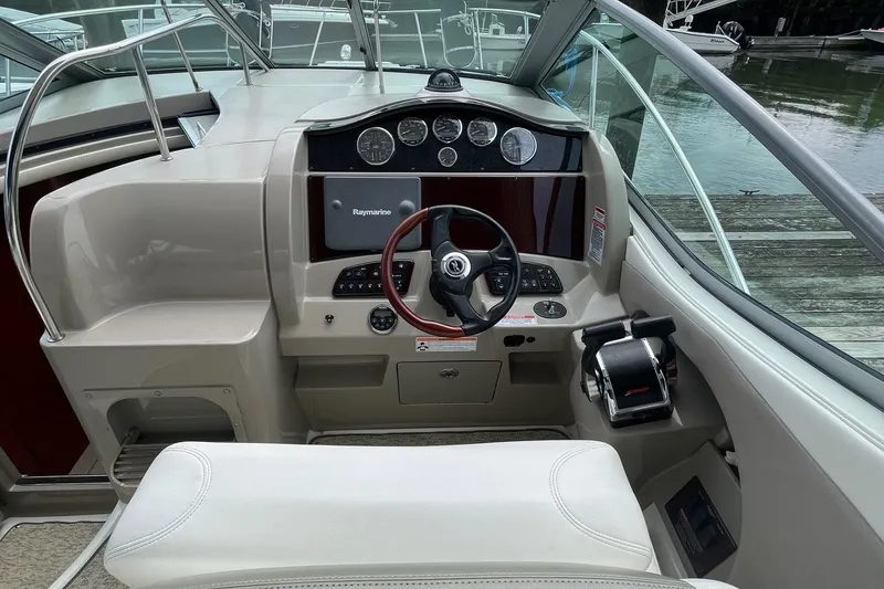 Slide: The Image of 2007 Sea Ray 290 Sundancer helm with steering wheel and navigation controls. - 2