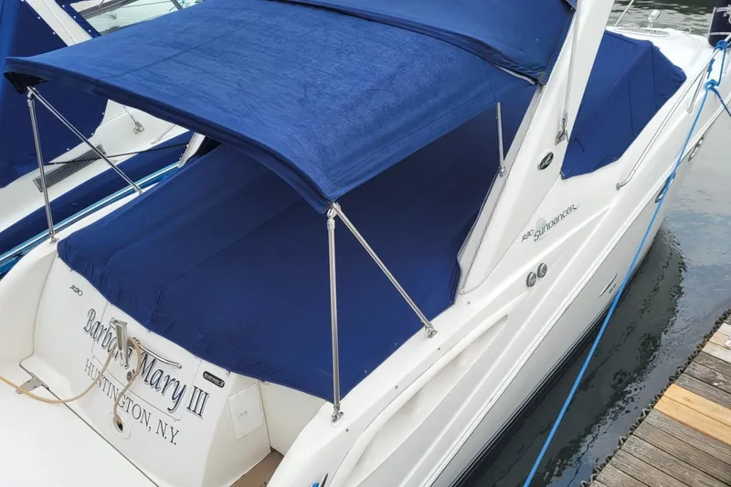 Slide: The Image of 2007 Sea Ray 290 Sundancer boat with blue canopy docked at marina. - 22