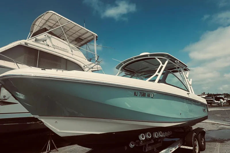 Slide: The Image of 2020 Boston Whaler 270 Vantage boat on trailer under clear blue sky. - 0