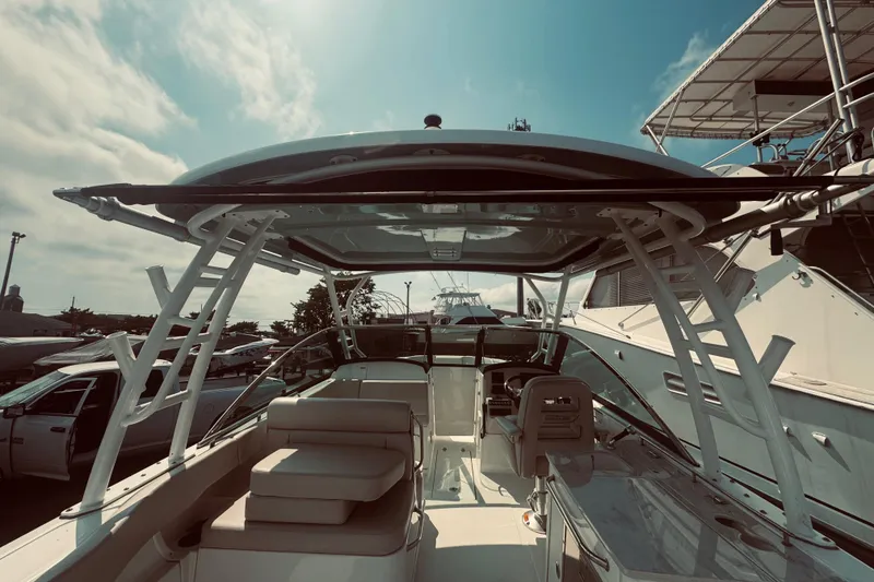 Slide: The Image of 2020 Boston Whaler 270 Vantage boat interior with seating and helm under a clear sky. - 18