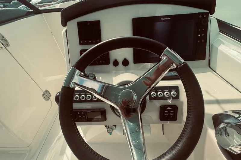 Slide: The Image of 2020 Boston Whaler 270 Vantage helm with steering wheel and navigation controls. - 27