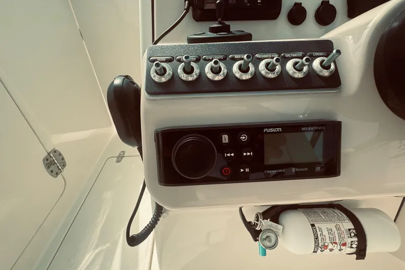 Slide: The Image of Control panel of a 2020 Boston Whaler 270 Vantage boat with switches and a fire extinguisher. - 28