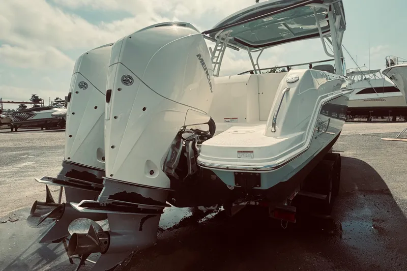 Slide: The Image of 2020 Boston Whaler 270 Vantage boat with dual outboard motors in a marina setting. - 7
