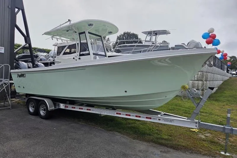 Slide: The Image of 2023 Parker 2600 Center Console boat on trailer, displayed outdoors with balloons. - 1