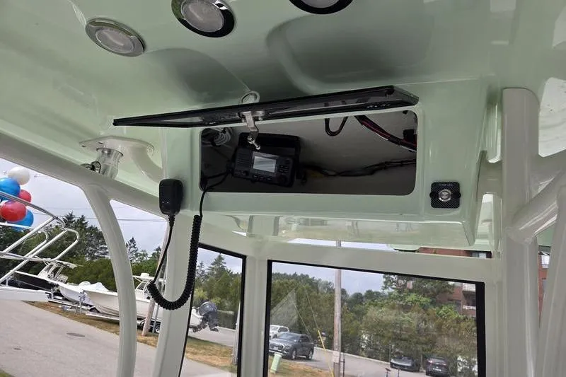 Slide: The Image of 2023 Parker 2600 Center Console boat interior with electronic equipment and overhead storage. - 16