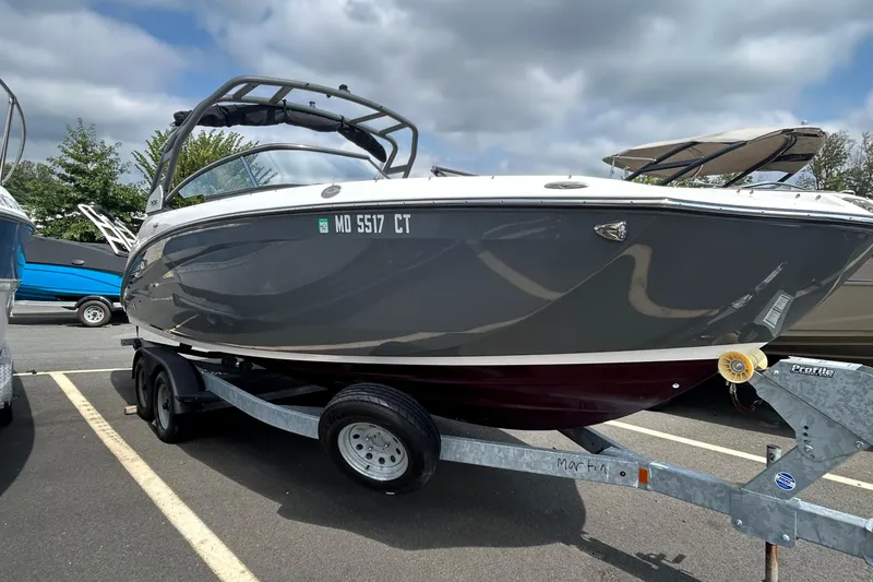 Slide: The Image of 2021 Yamaha Boats 252S on trailer, parked outdoors under cloudy sky. - 0