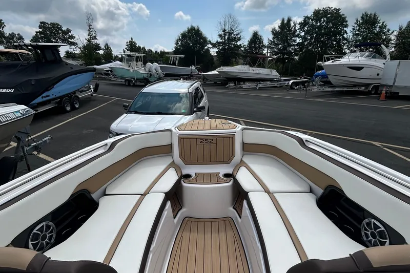 Slide: The Image of 2021 Yamaha Boats 252S interior with white seating, parked in a marina. - 4