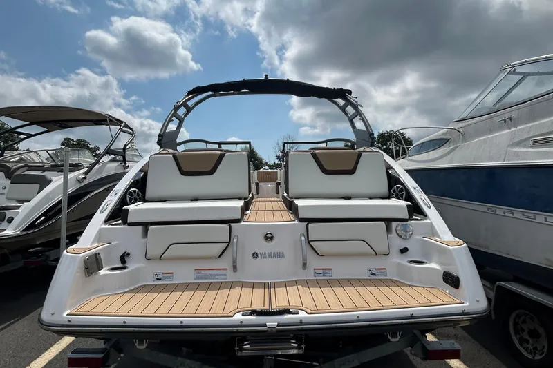 Slide: The Image of 2021 Yamaha Boats 252S with sleek design and spacious seating, docked under cloudy skies. - 9
