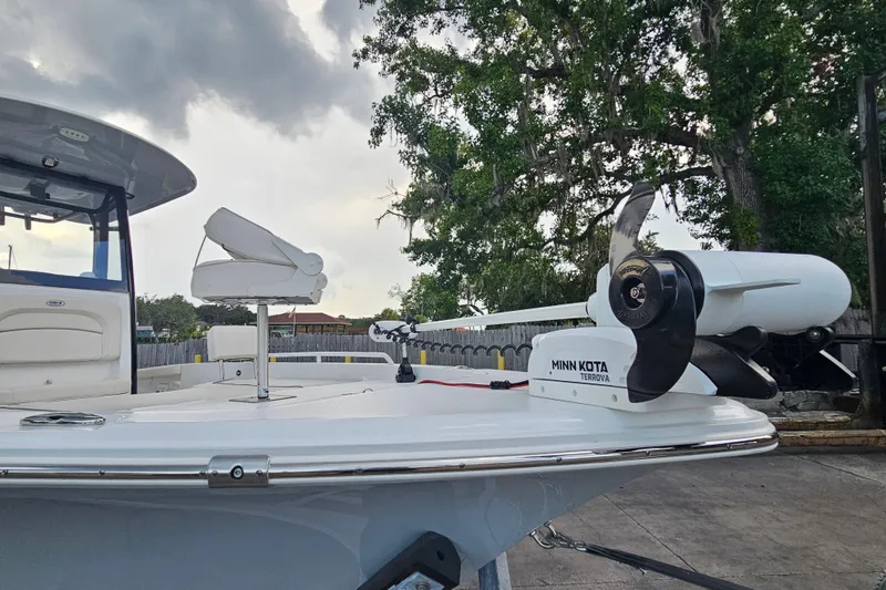 Slide: The Image of 2023 Sea Hunt BX 25 FS boat with Minn Kota Terrova motor, docked under cloudy sky. - 10