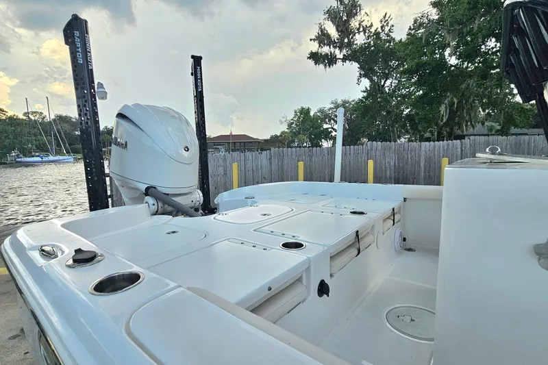 Slide: The Image of 2023 Sea Hunt BX 25 FS boat with Yamaha engine, docked near a wooden fence. - 11